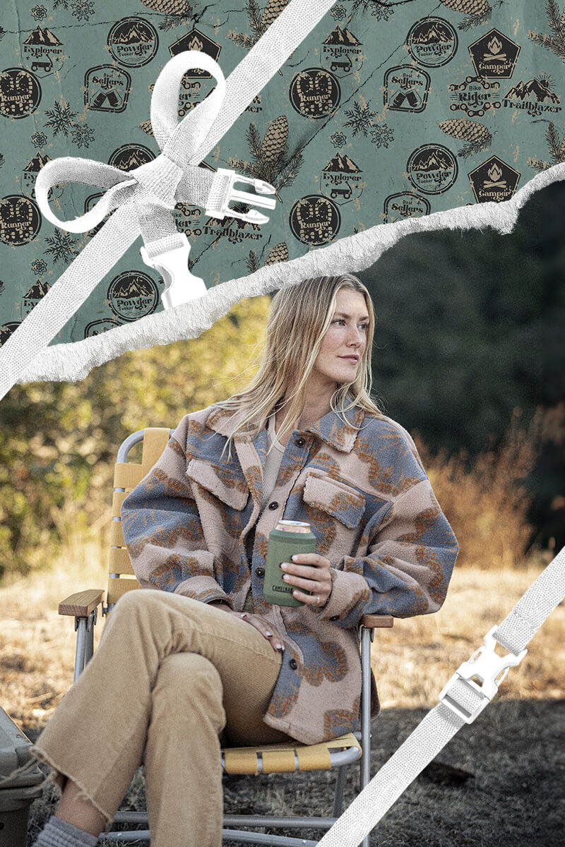 A woman sitting in a camp chair with a can cooler in her hand with holiday themed wrapping paper framing the area around them. 