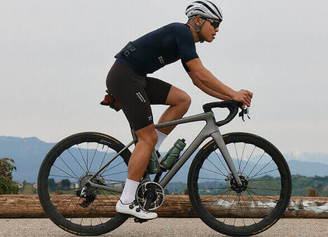 Cyclist riding with two podium steel bottles in their bike cages.