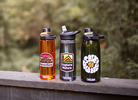 Three custom bottles sitting on a railing.